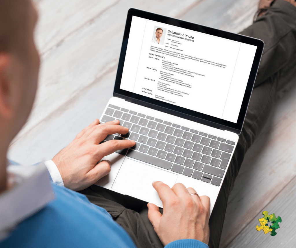 A man looking at a laptop screen showing a CV