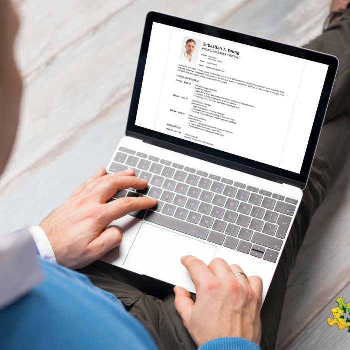 A man looking at a laptop screen showing a CV