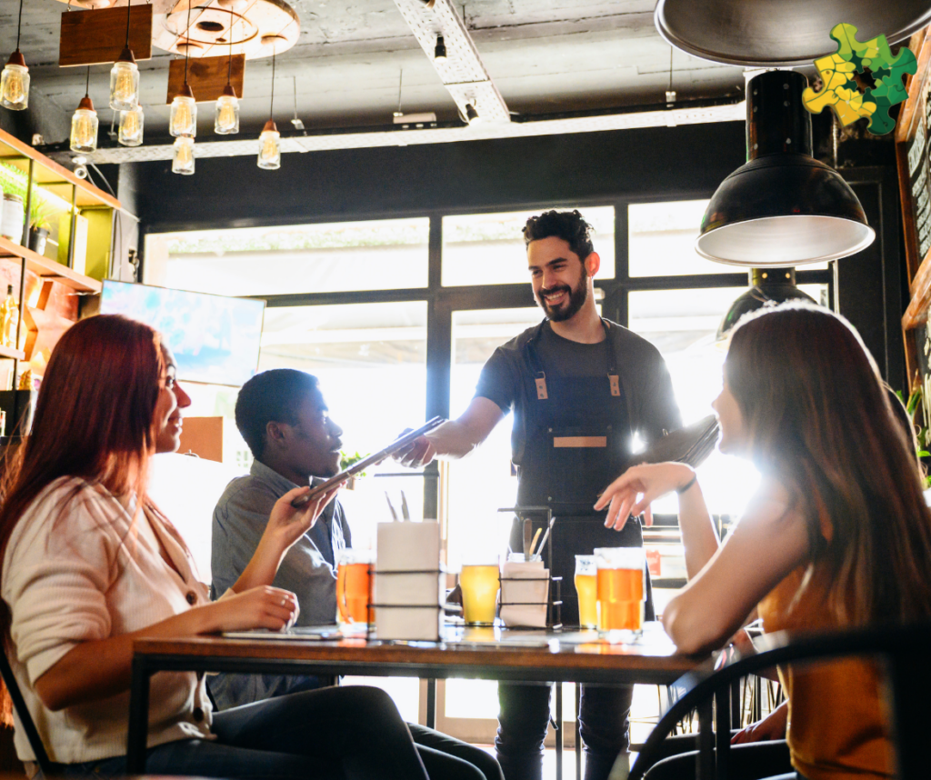 A Waiter talking with clients seating at a table